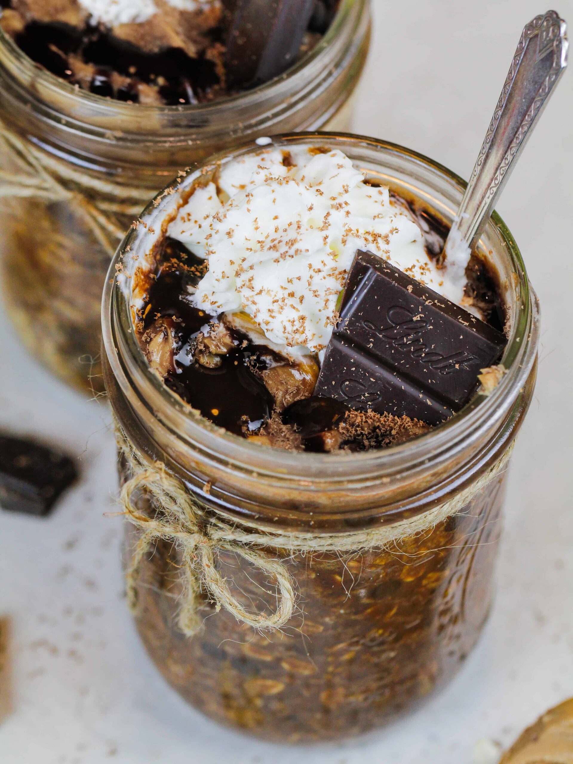 image of chocolate overnight oats topped with whipped cream and a piece of chocolate