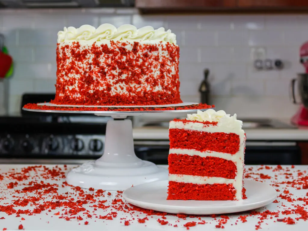 image of sliced red velvet cake, decorated with cake crumbs