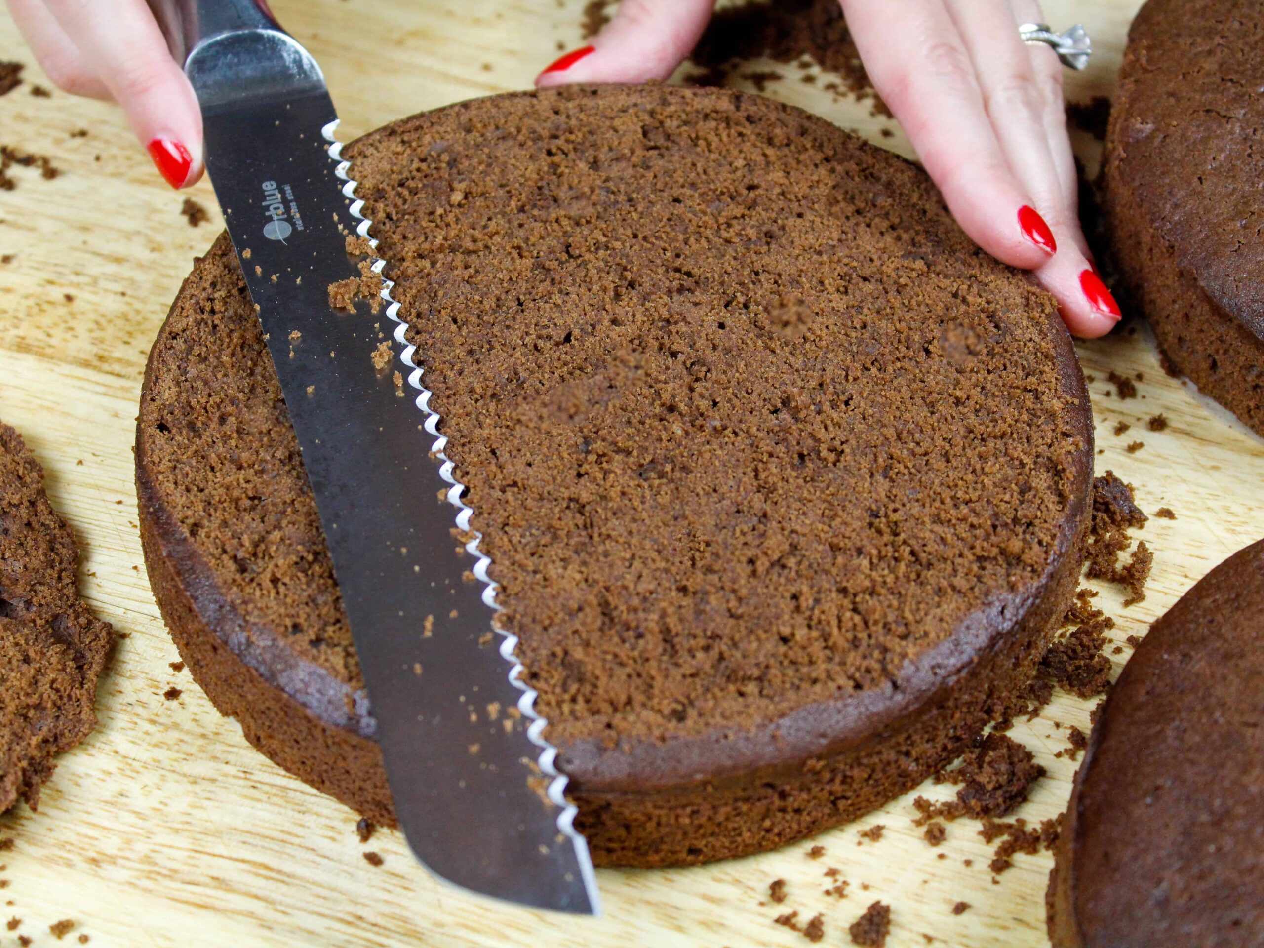 image of mocha chocolate cake layers being leveled with a serrated knife