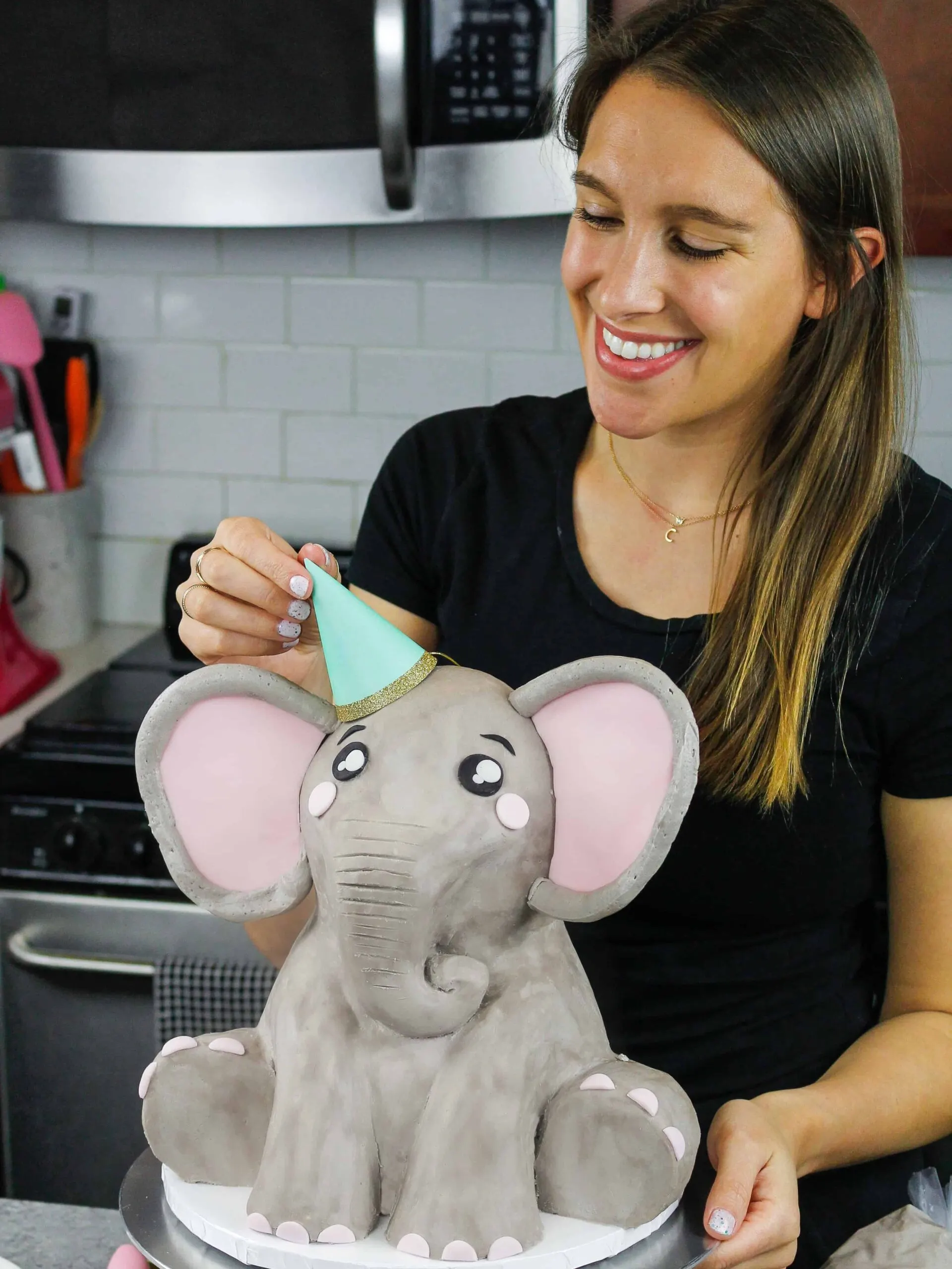 image of an elephant cake being made for a baby shower with a party hat