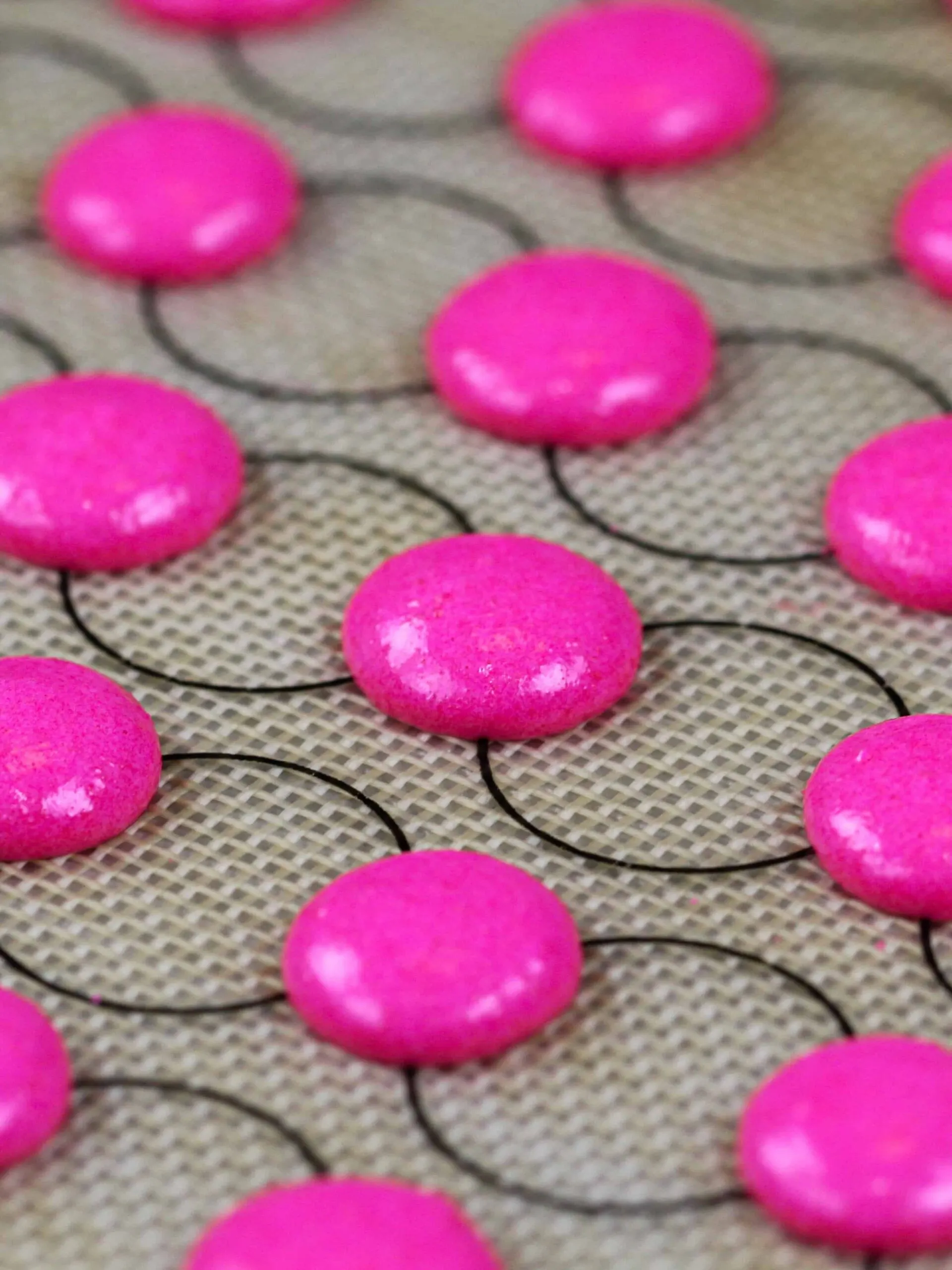 image of mini pink macaron shells that've been piped and are resting before being baked