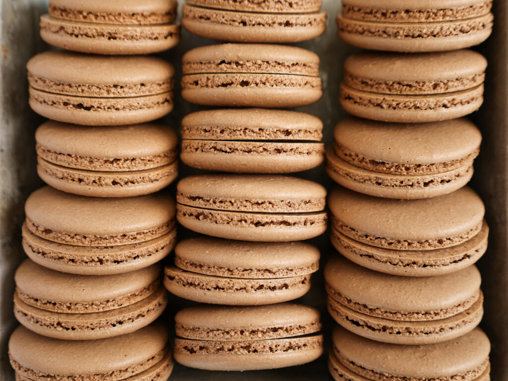 image of french chocolate macaron shells that have been baked and have perfect feet