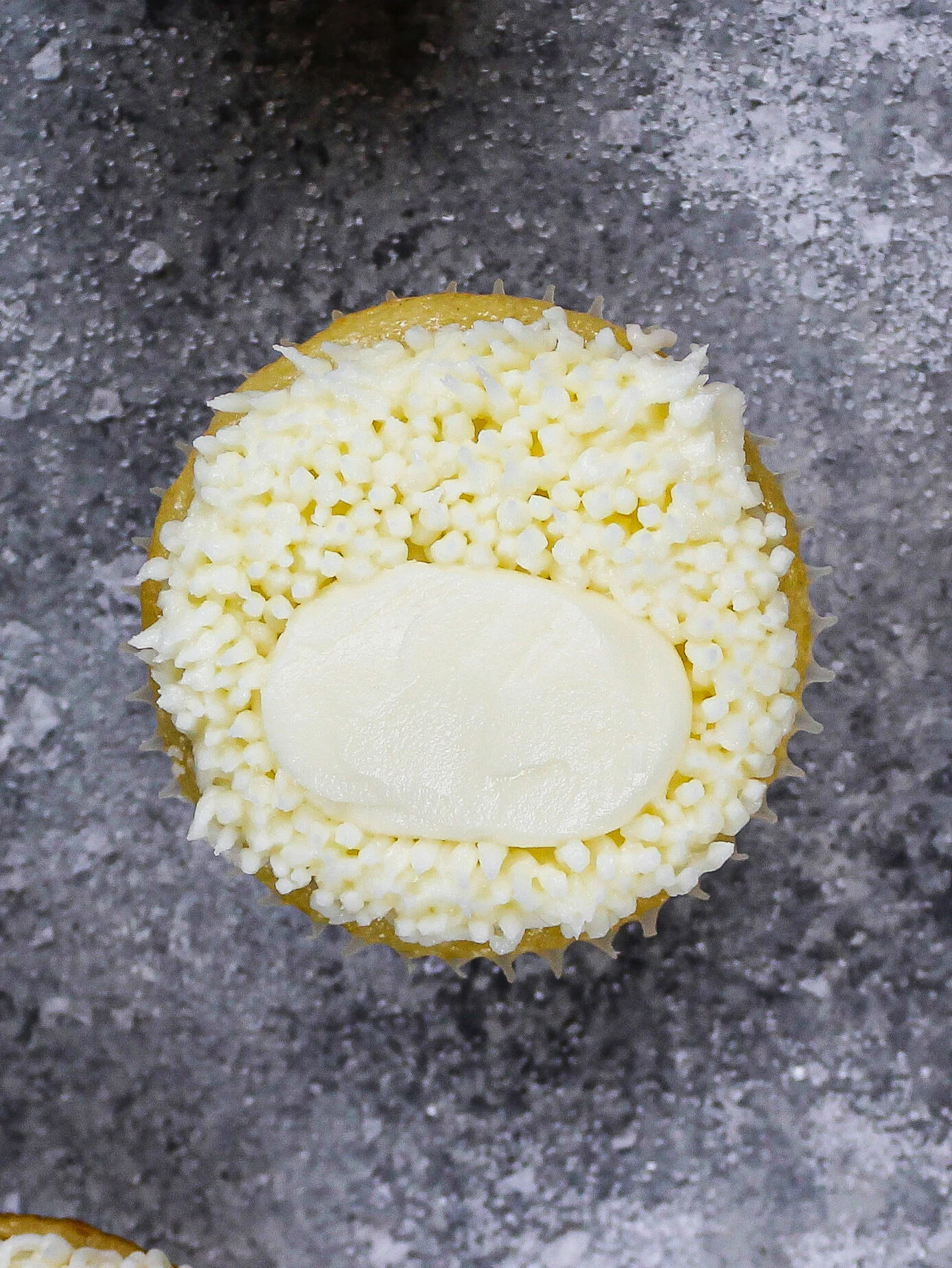 image of a white cupcake piped with buttercream fur to make a polar bear cupcake