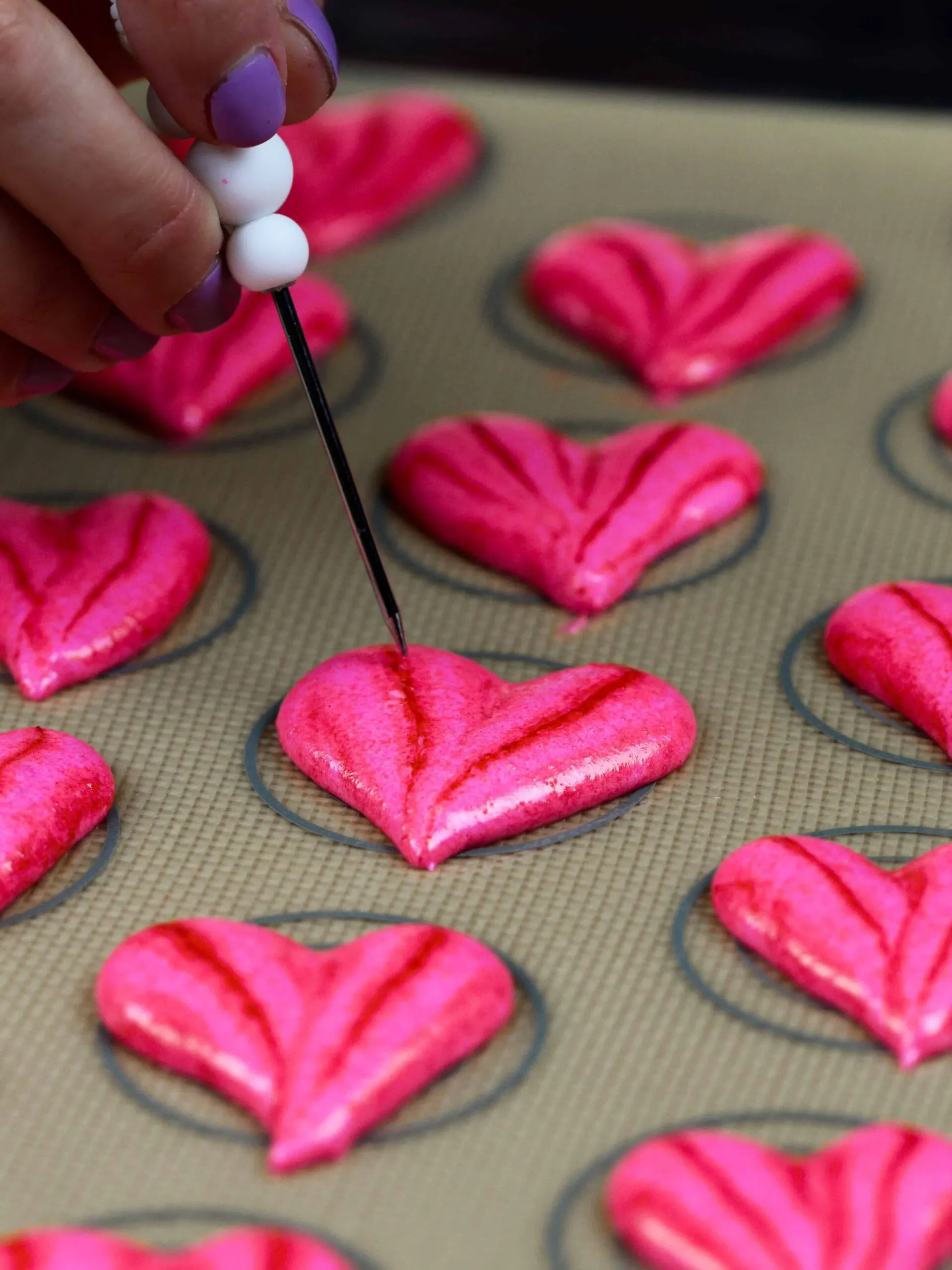 image of heart shaped macaron shells that have been piped and are resting
