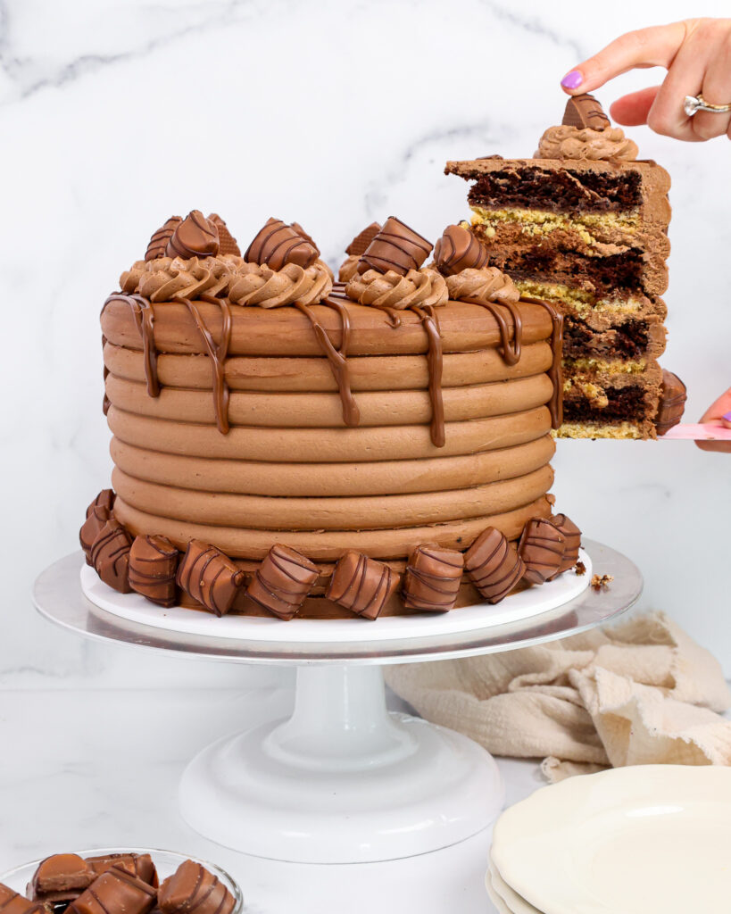image of a kinder bueno cake being cut into and a slice of cake being pulled out
