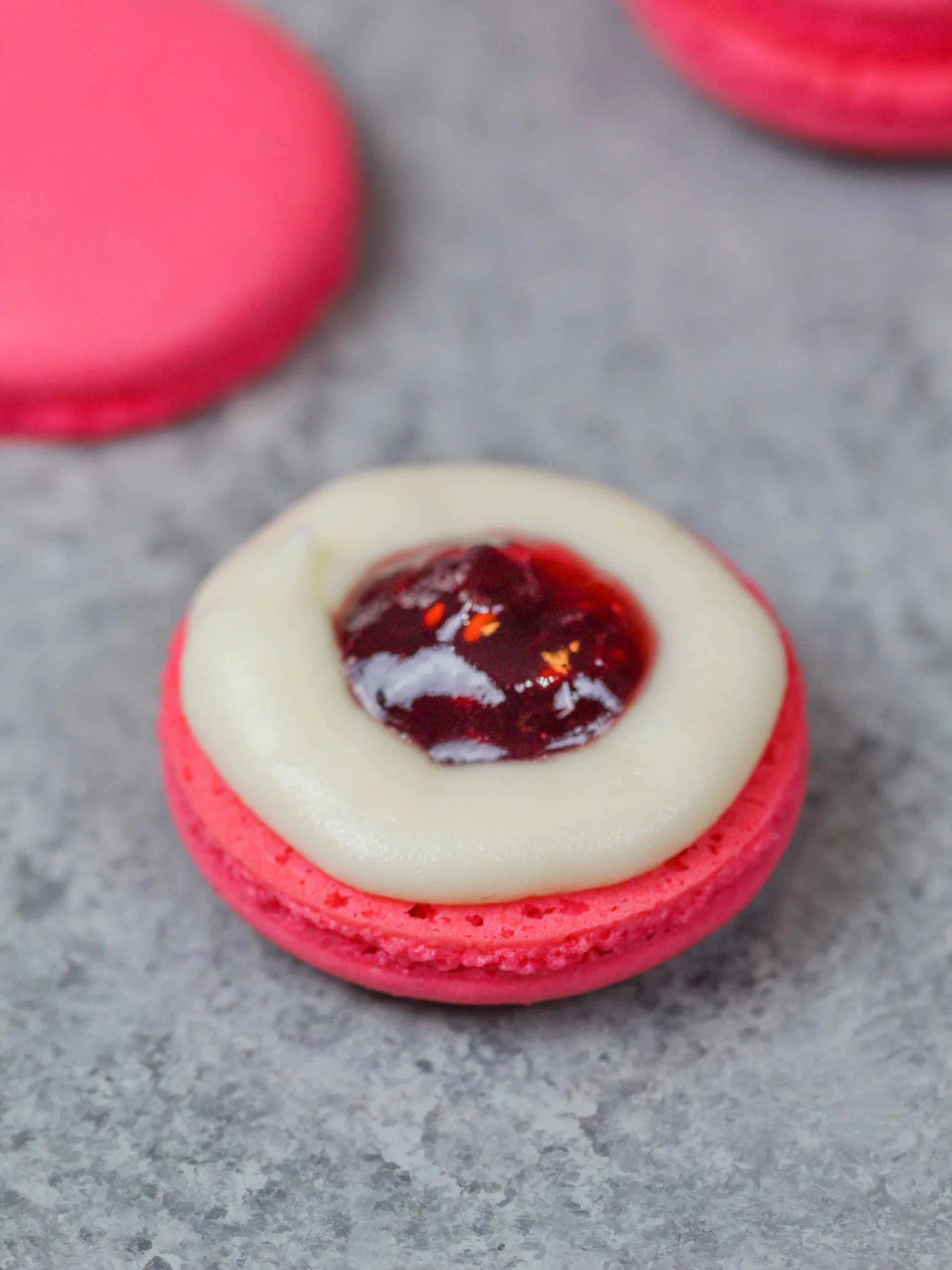 image of pink french macaron shells filled with homemade buttercream and raspberry jam