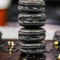 image of black macarons made using the french technique and filled with black cocoa buttercream