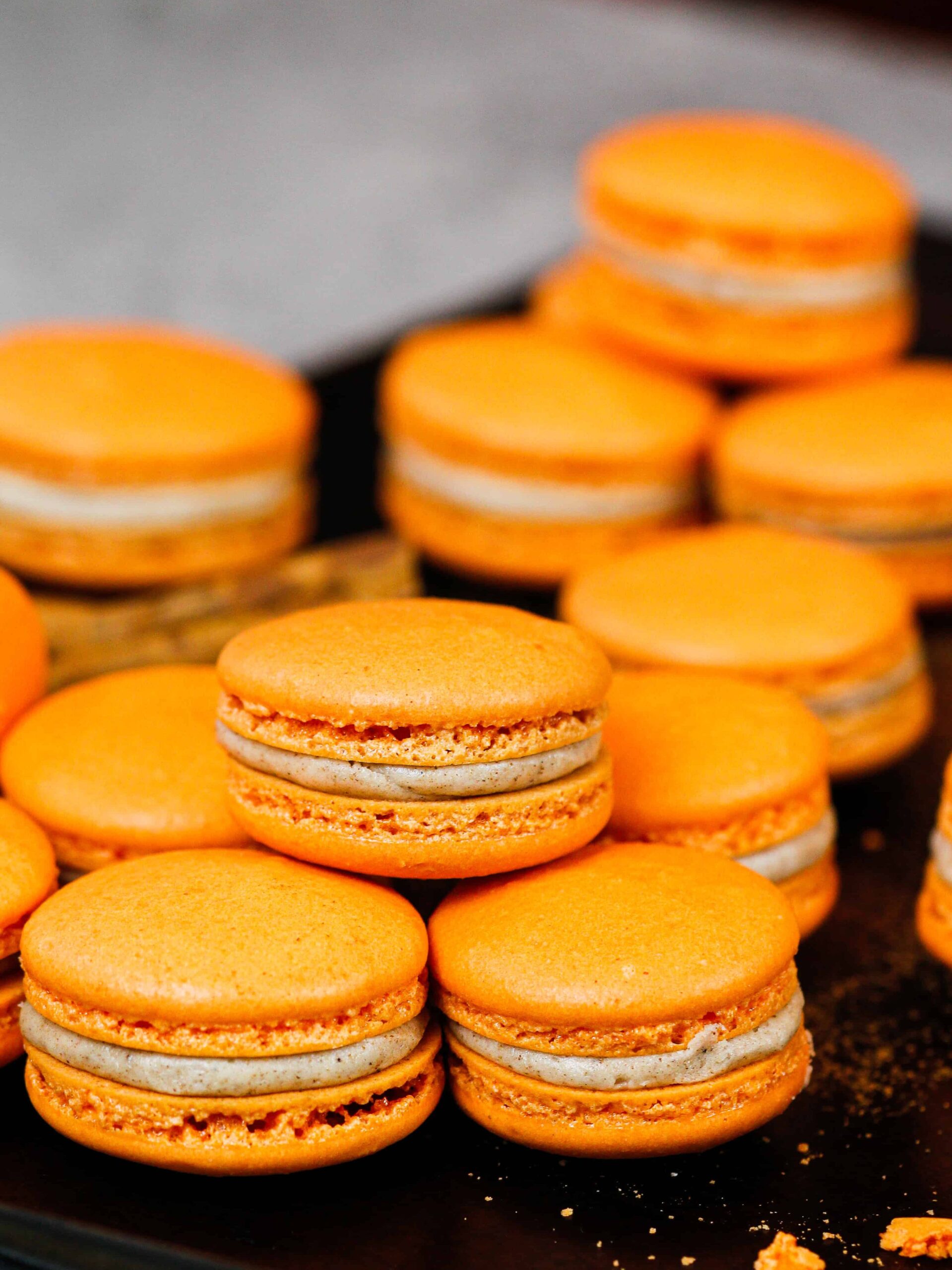 image of pumpkin macarons on a baking tray