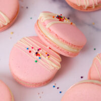 image of Italian macarons filled with white chocolate ganache topped with white chocolate and sprinkles