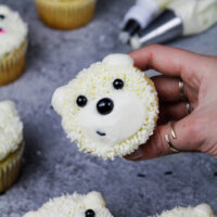 image of adorable polar bear cupcakes made with buttercream frosting and black sprinkles