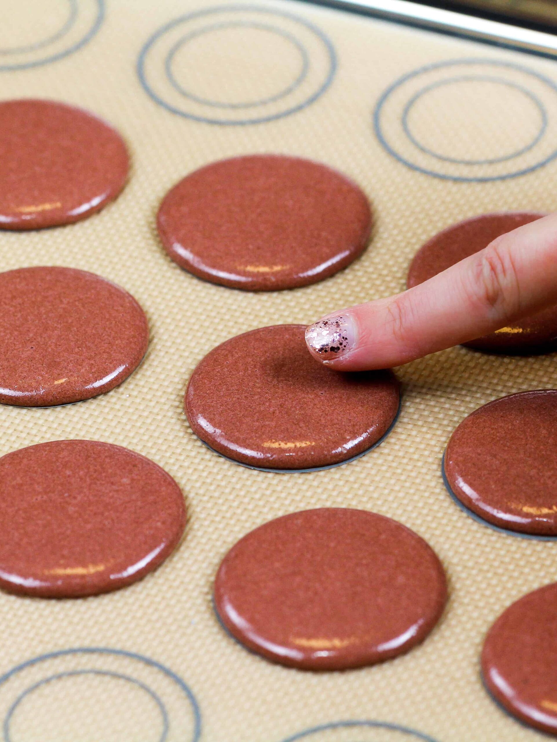 image of brown french macaron shells that have been rested and have formed a skin
