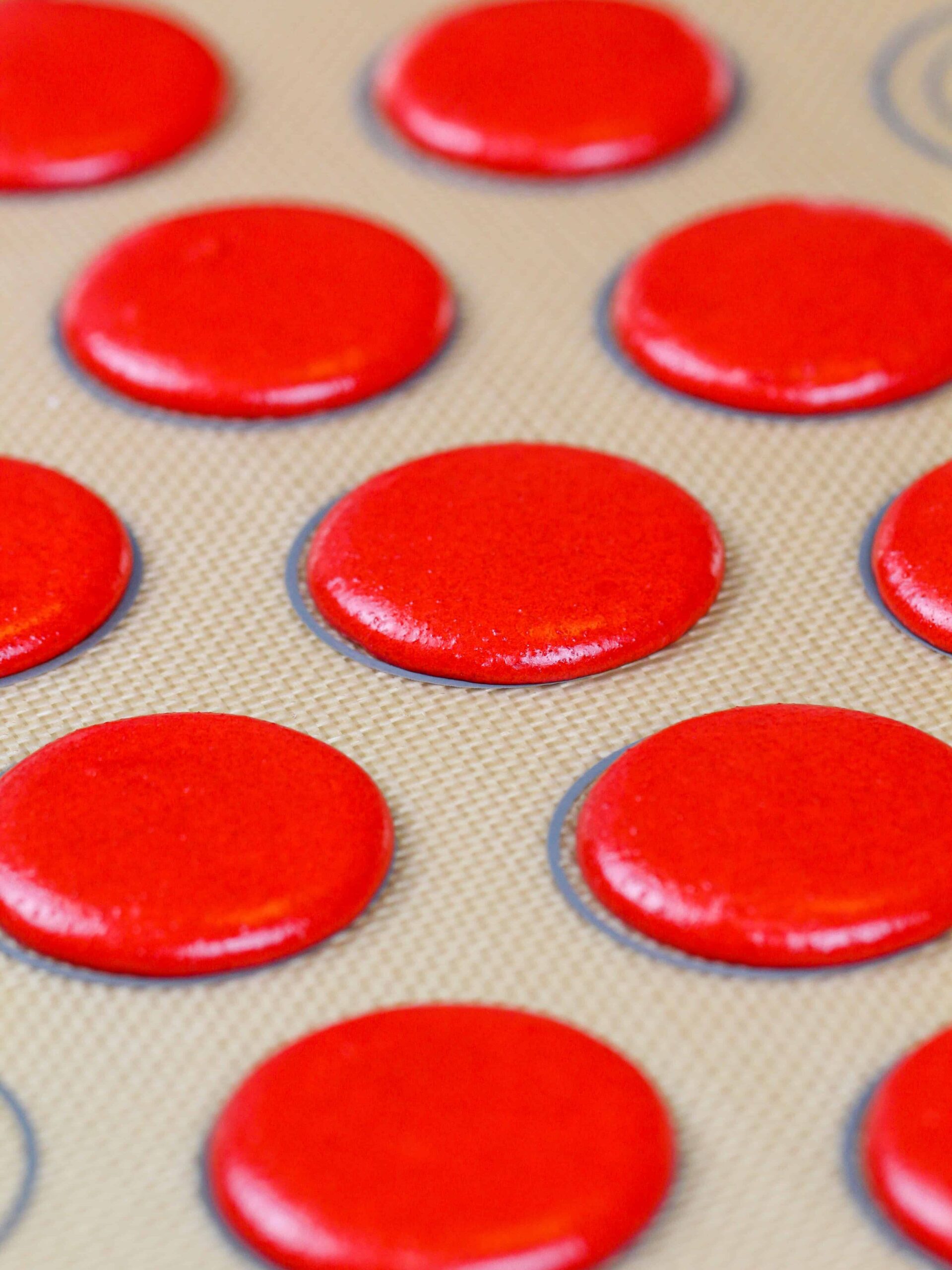 image of red velvet macarons that have been rested to form a skin before being baked