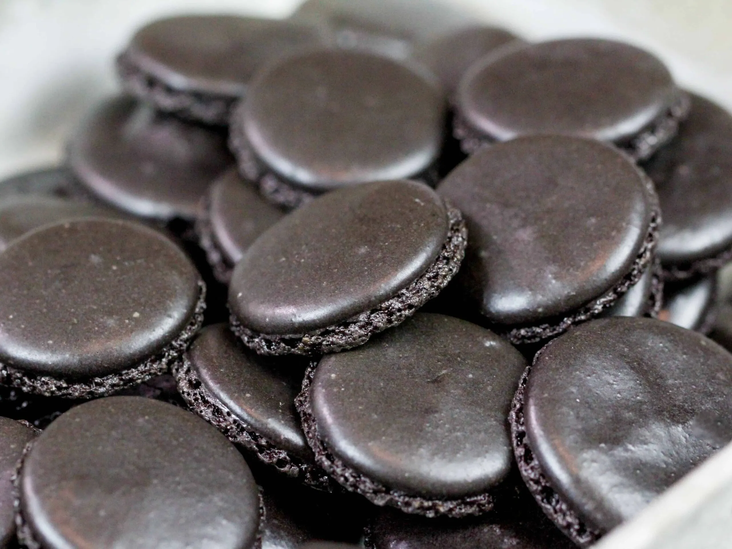 image of black macaron shells that have been baked and cooled and are ready to be filled