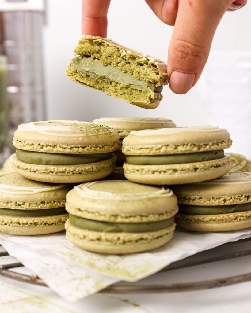 image of matcha macaron that's been cut open to show it's full shells and matcha ganache filling