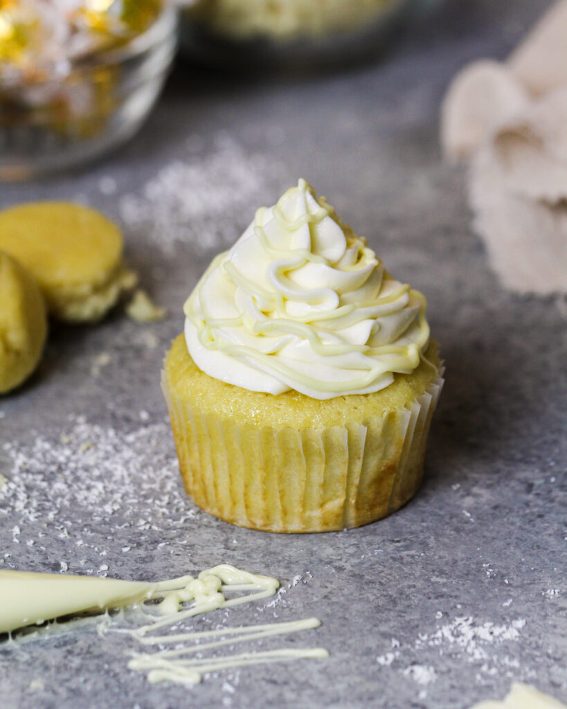 image of white chocolate cupcakes being topped with a drizzle of melted white chocolate