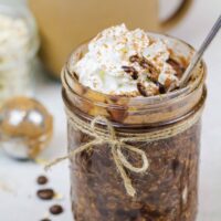 image of coffee overnight oats topped with whipped cream and chocolate syrup