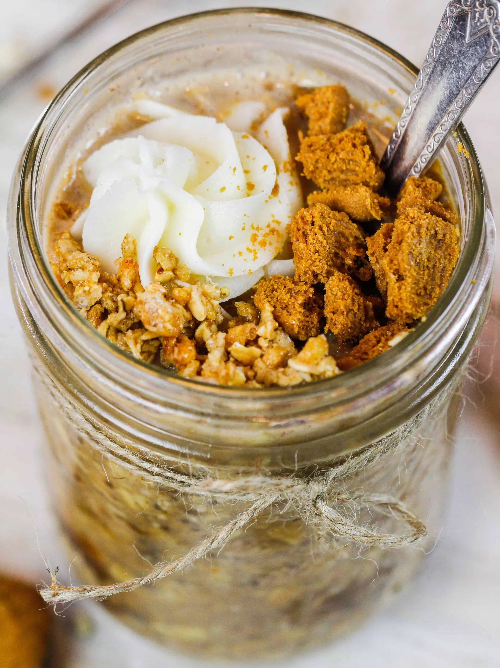 image of a jar of biscoff overnight oats topped with whipped cream and biscoff cookies