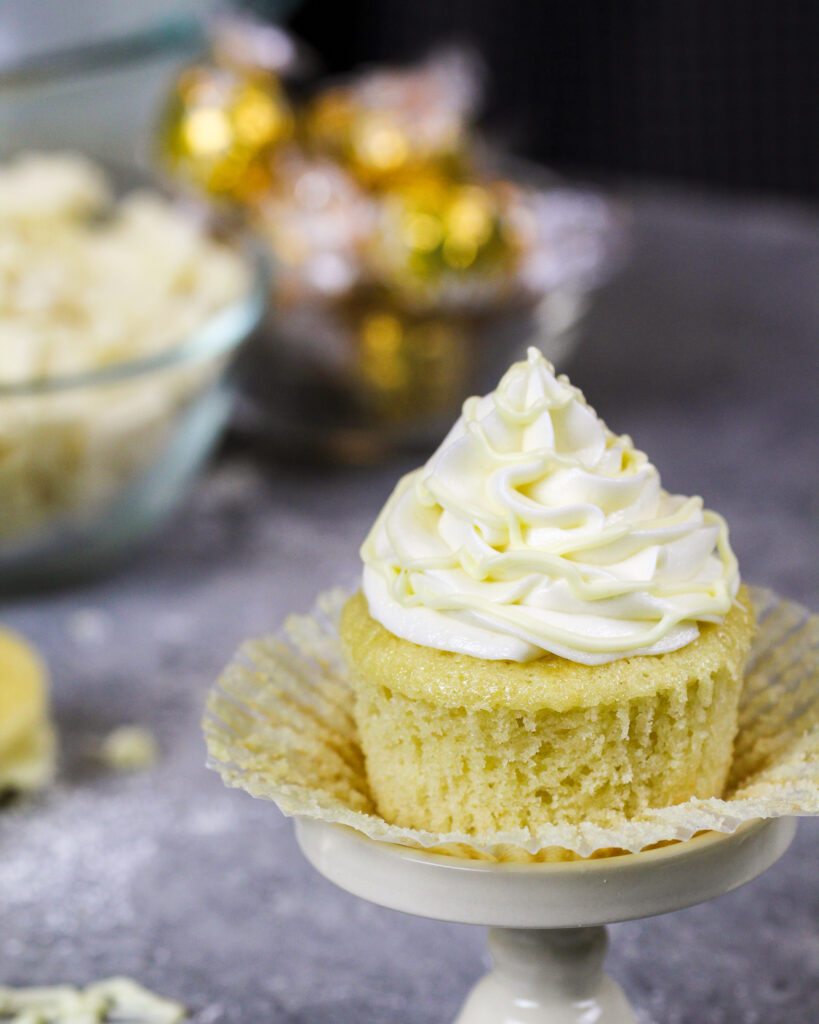 image of a white chocolate cupcake that's been unwrapped to show how tender and fluffy it is