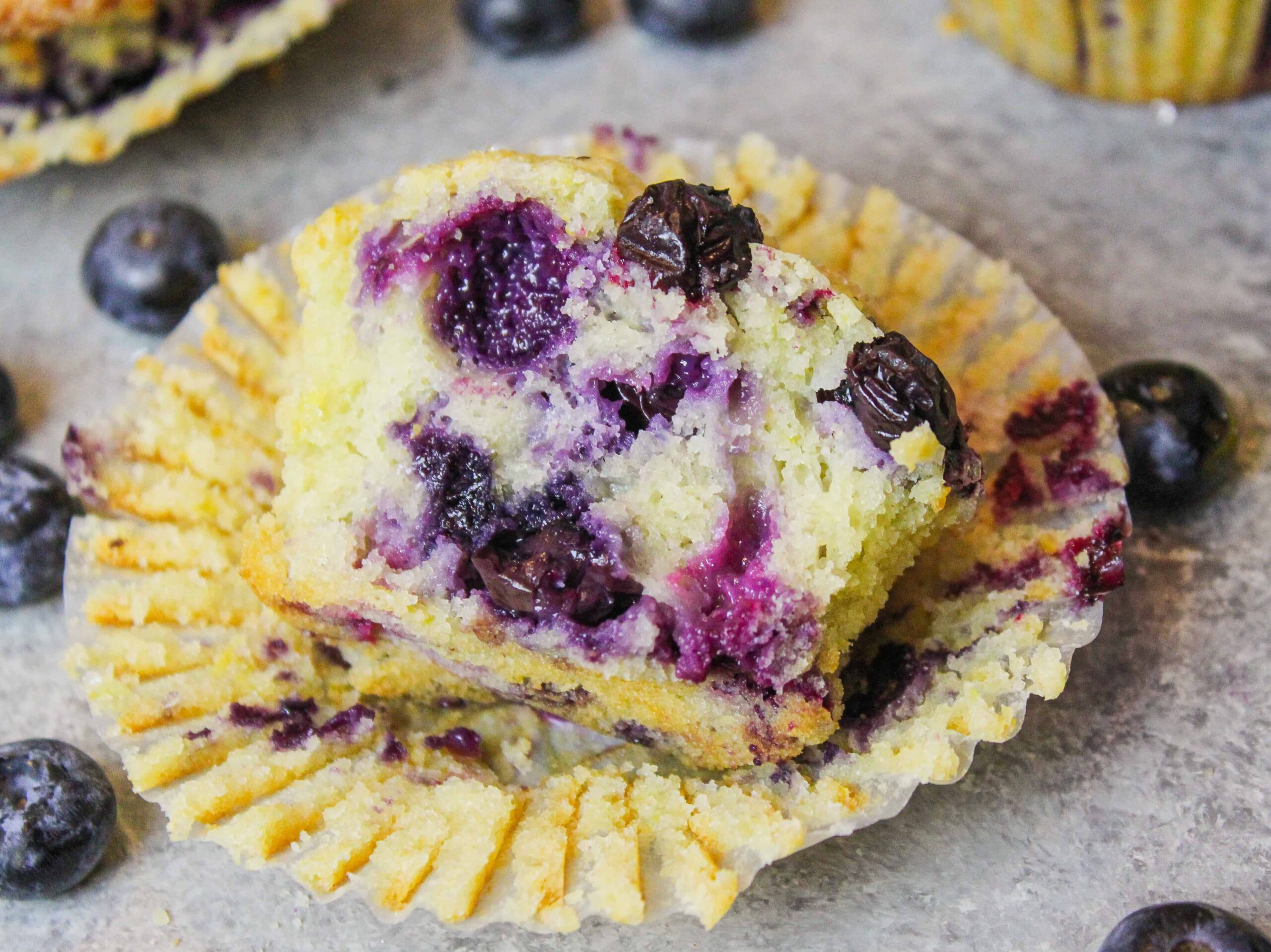 image of cut open blueberry muffin, showing moist, tender crumb and juicy blueberries