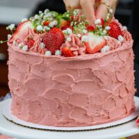 image of vanilla strawberry cake with vanilla cake layers and strawberry buttercream