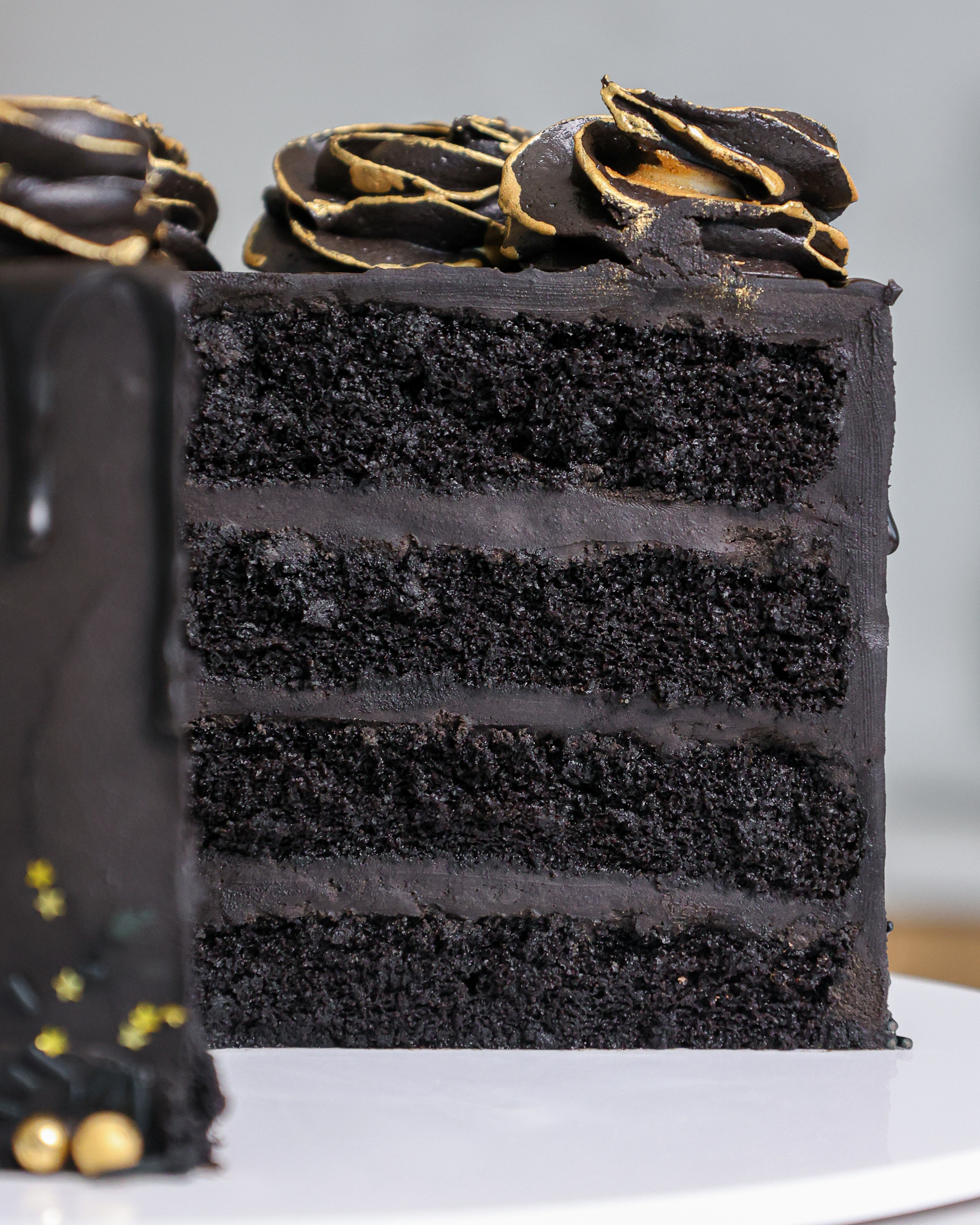 image of a black velvet layer cake that's been frosted with a delicious black dark chocolate buttercream