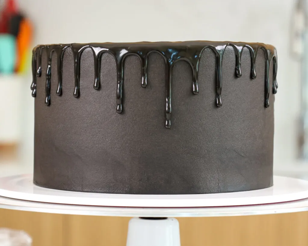 image of a black cake that's been decorated with a black chocolate ganache drip
