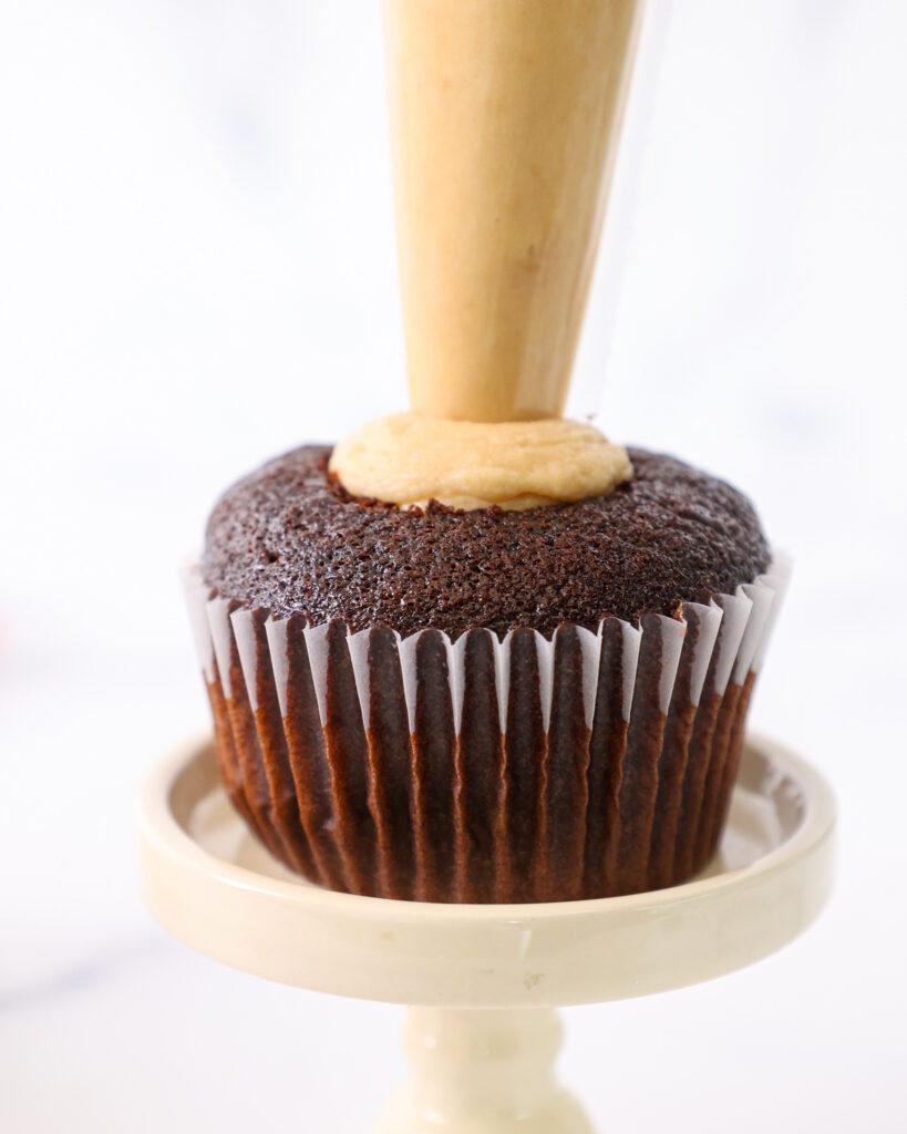 image of a chocolate cupcake being filled with a hazelnut mousse 