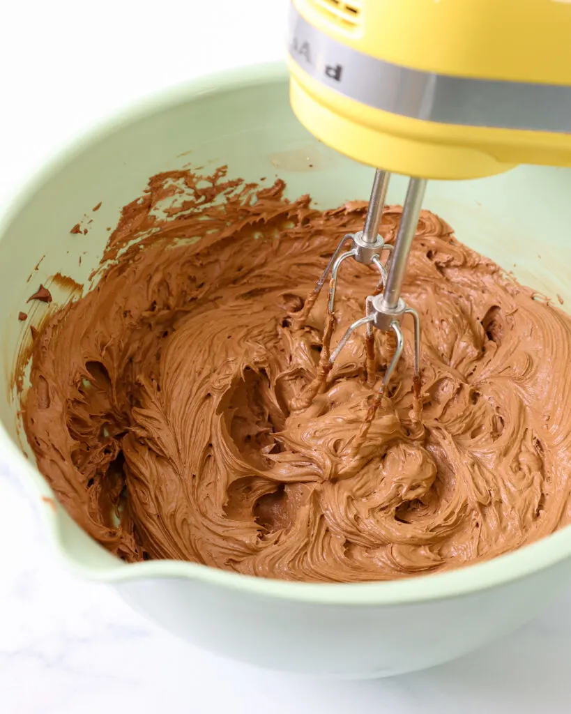 image of chocolate hazelnut buttercream being mixed with a hand mixer