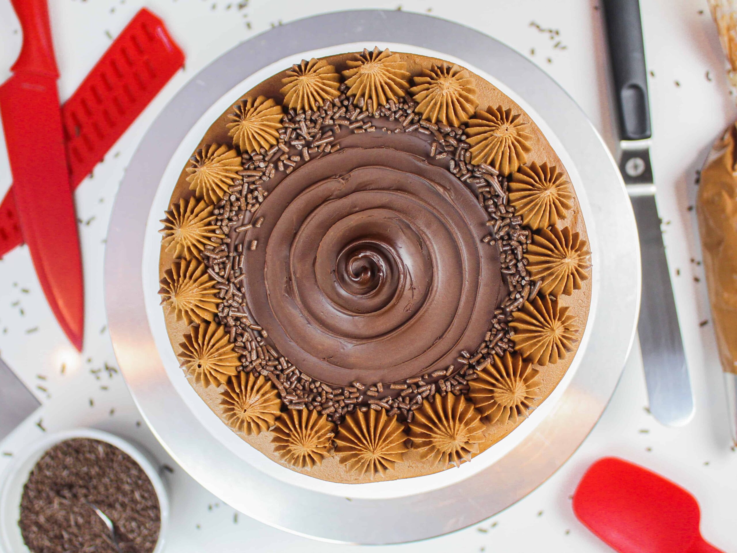 image of gluten free chocolate cake from overhead, decorated with a chocolate swirl and buttercream dollops