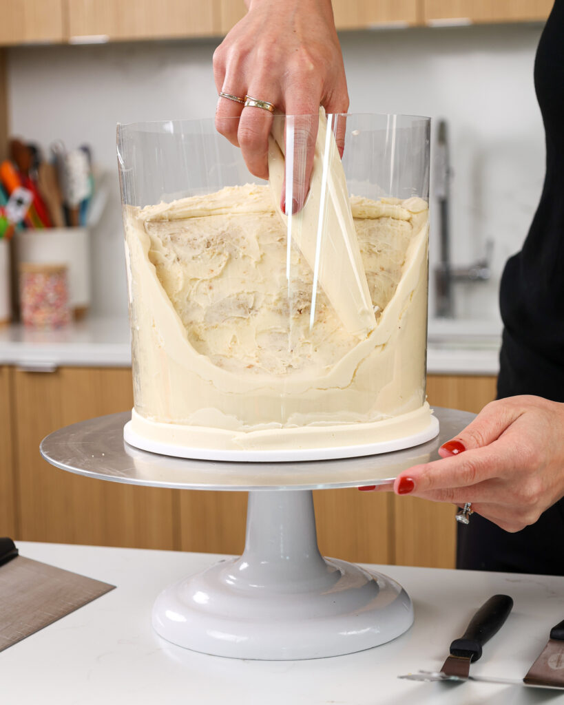 image of a cake being wrapped with an acetate sheet to help seal it before pouring in a gelatin ocean