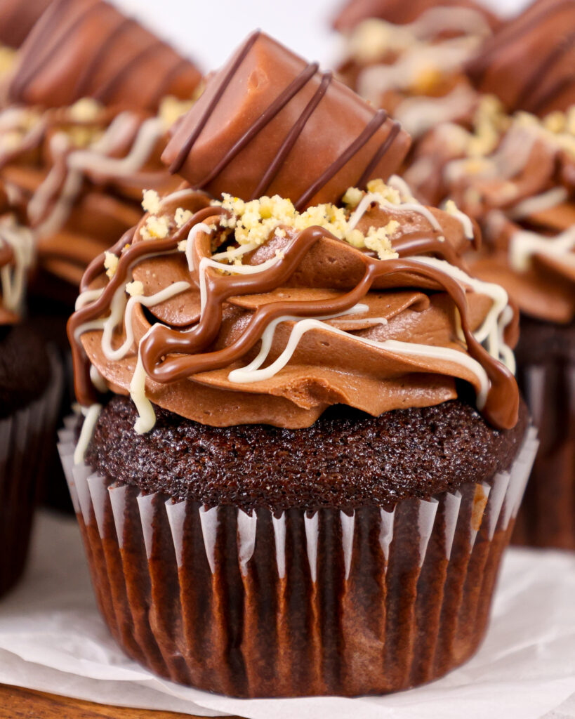 image of a kinder bueno cupcake that's been filled with hazelnut mousse and frosted with hazelnut chocolate buttercream frosting