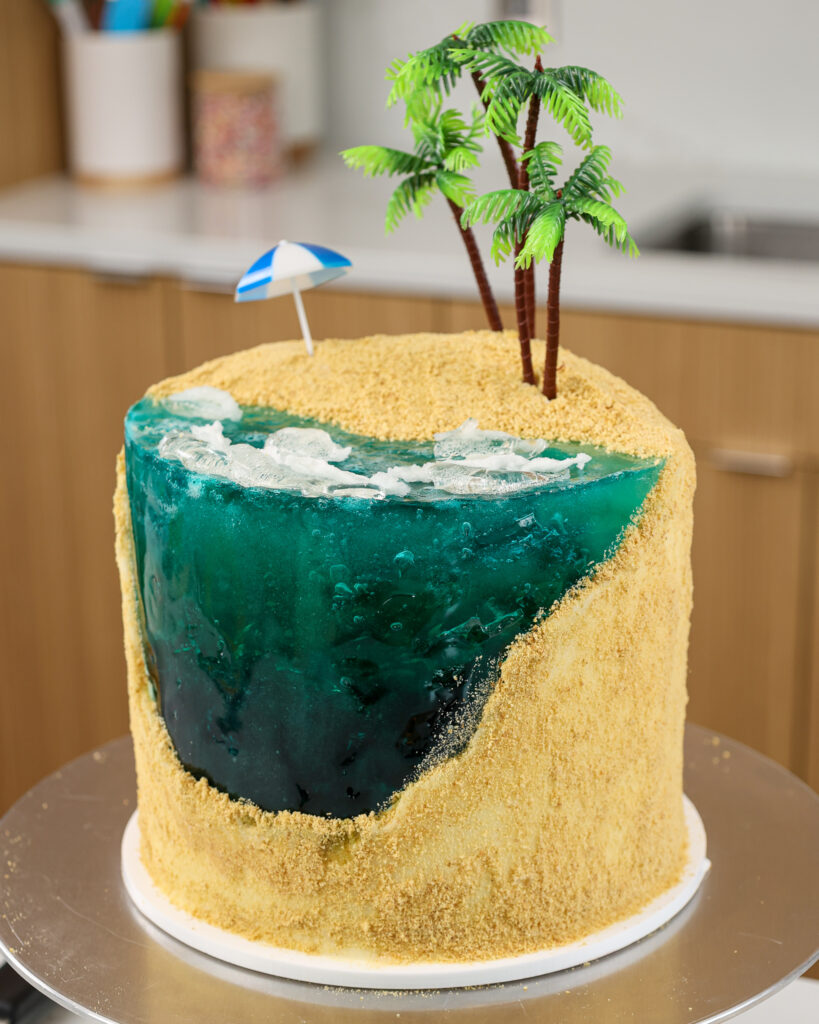 image of a beach cake made with blue gelatin and graham cracker sand