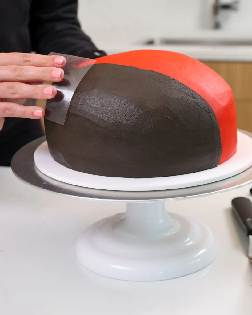 image of black frosting being smoothed onto a cake 