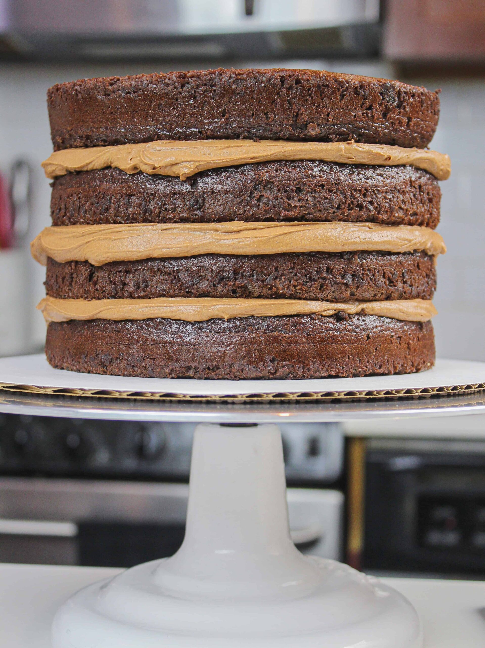 image of gluten free chocolate cake layers stacked with dark chocolate buttercream
