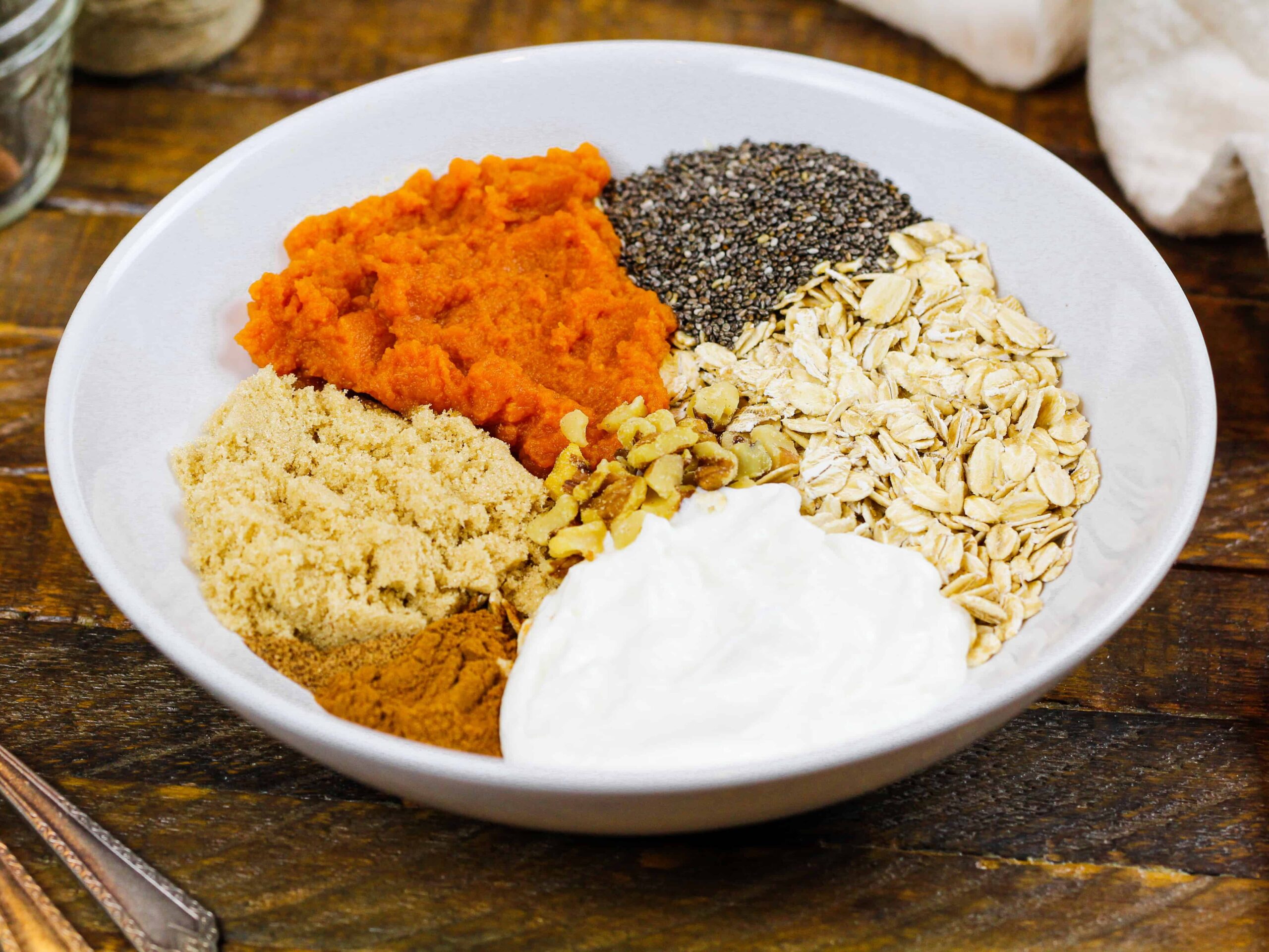 image of ingredients in a bowl ready to make pumpkin spice overnight oats
