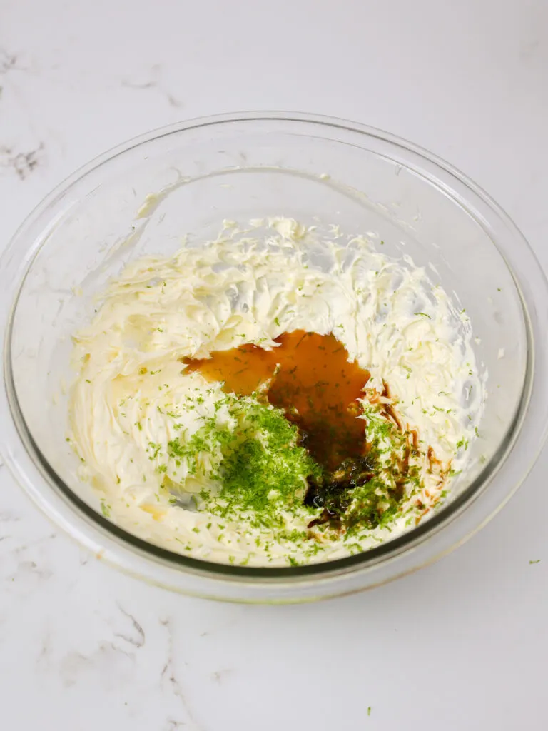 image of lime zest, salt, and vanilla extract being mixed into butter 