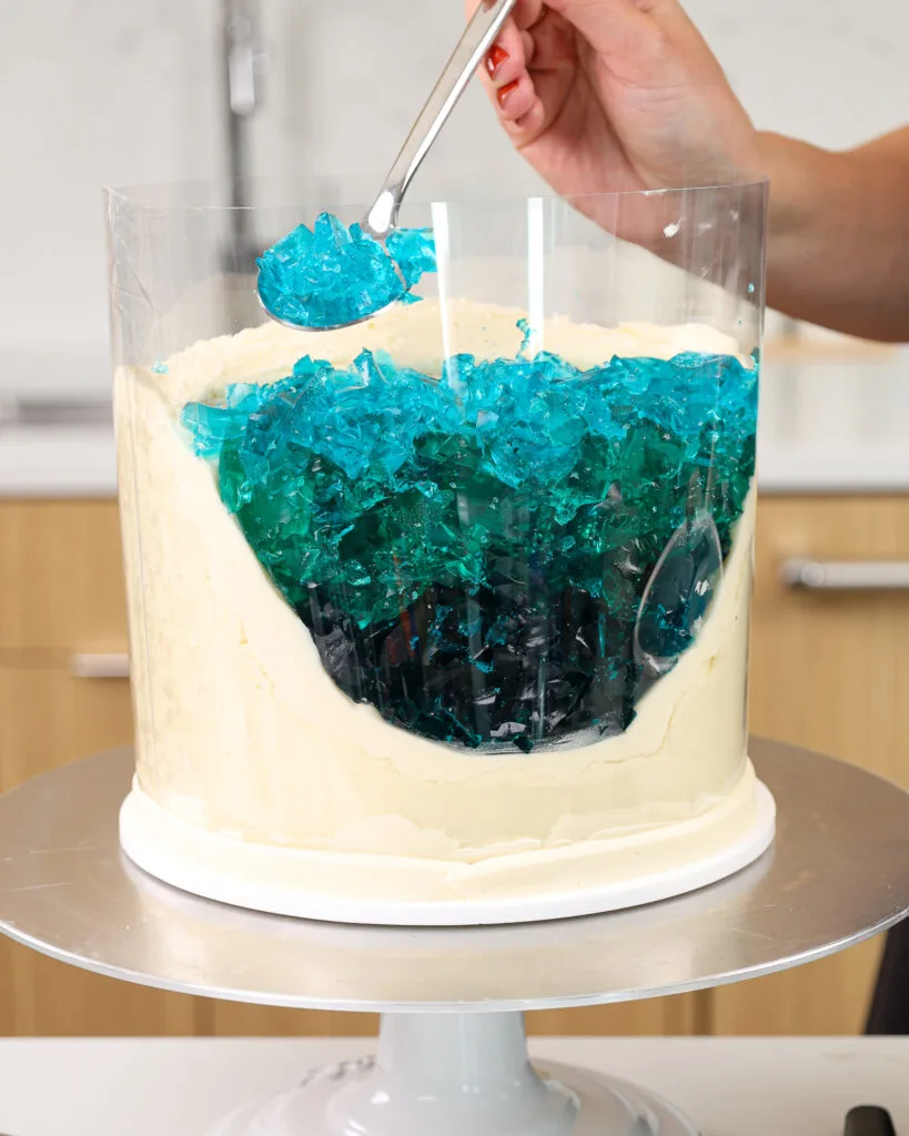 image of blue gelatin crumbles being added into a cake to make a jelly ocean
