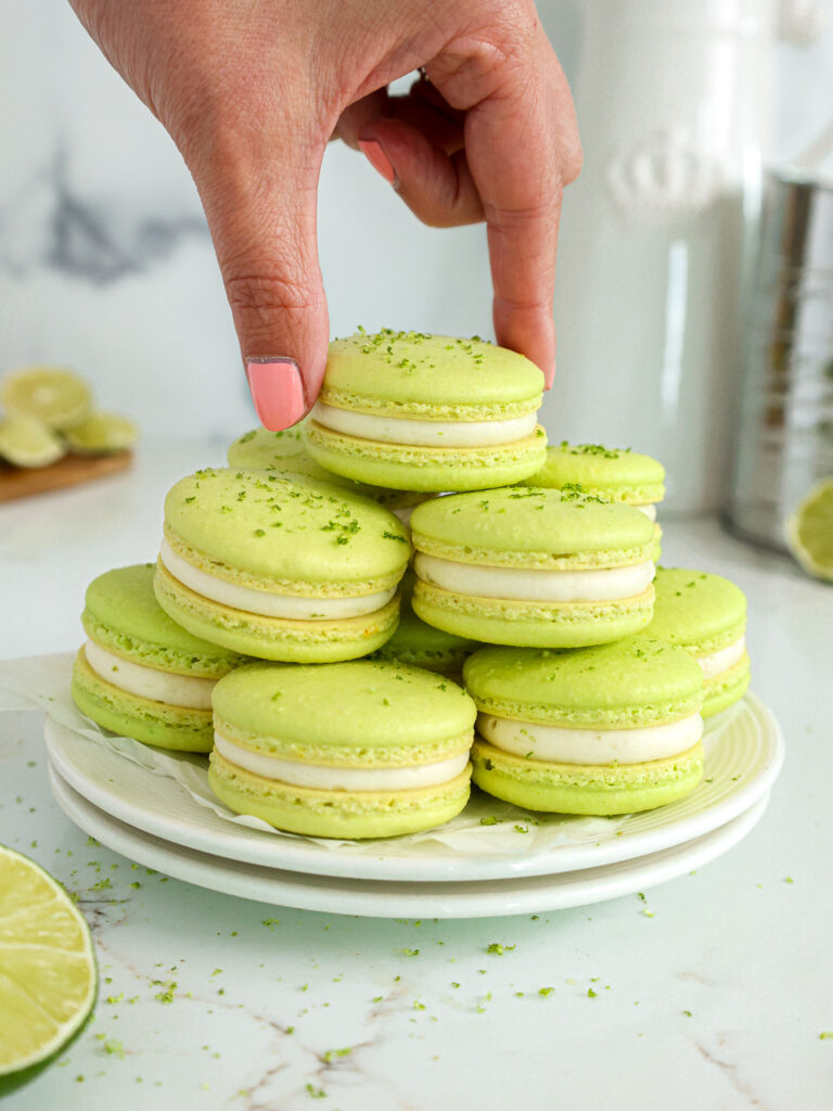 image of lime macarons stacked on a plate that have been filled with homemade lime curd