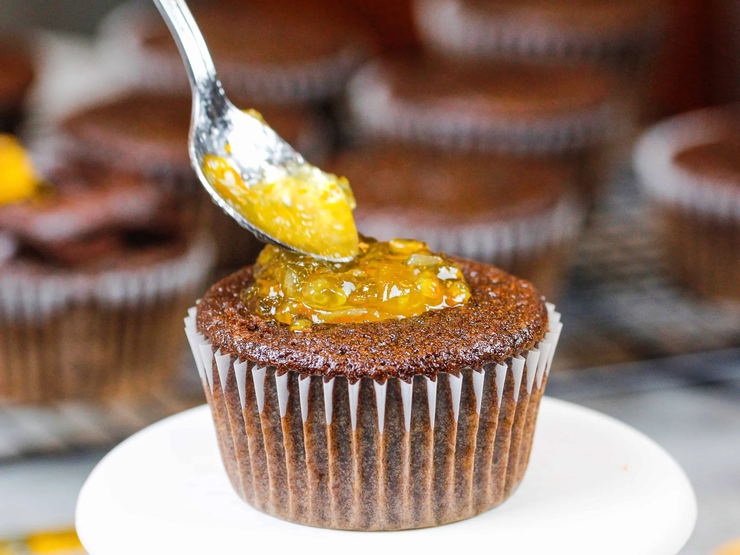 image of chocolate cupcakes being filled with orange marmalade