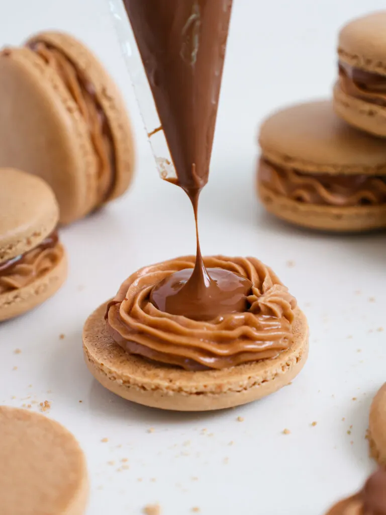image of a nutella macaron being filled with a straight up nutella center