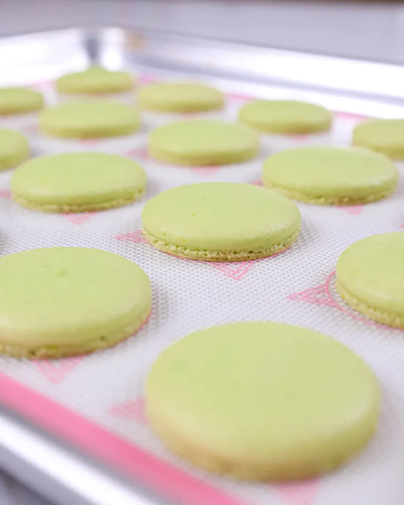 image of green macaron shells that have baked up with nice, even feet