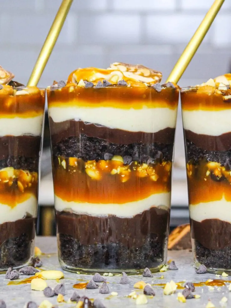 image of snickers trifles made in individual glasses to make them easy to serve and eat that's shared as part of a no bake dessert round up