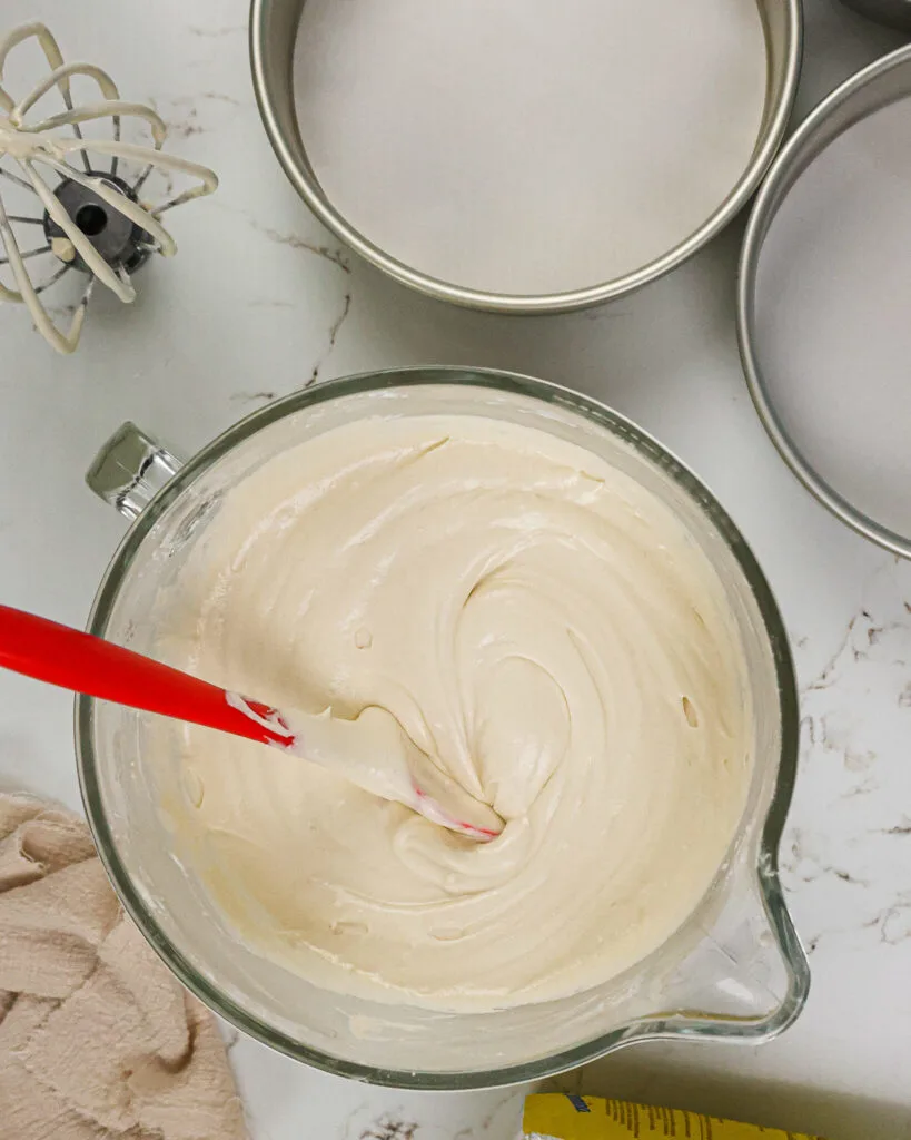 image of fluffy vanilla cake batter being mixed and that's ready to be poured into the prepared pans to be baked