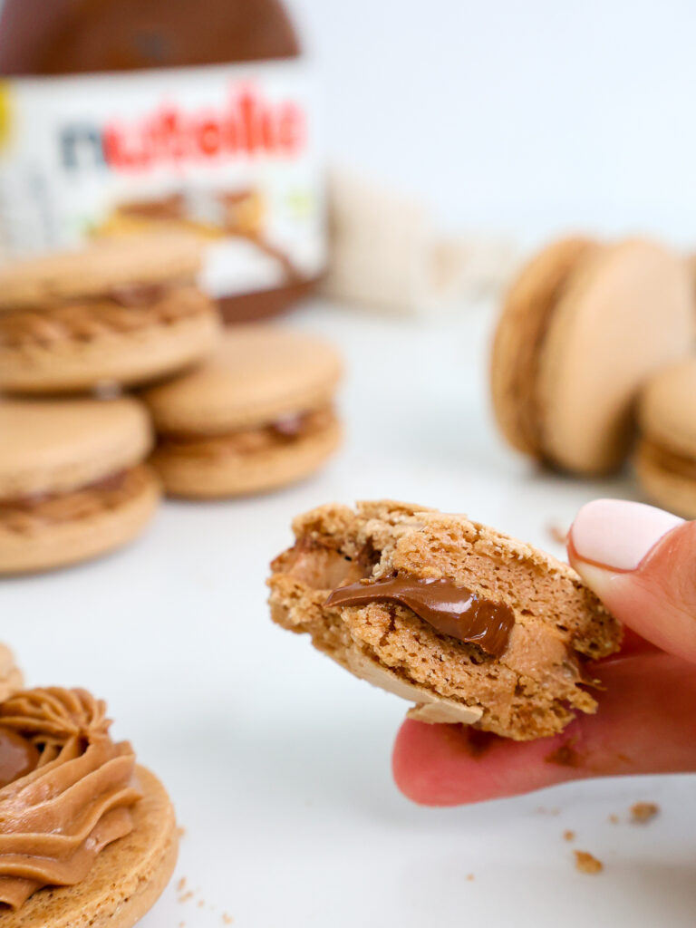image of a Nutella macaron that's been bitten in half to show its delicious Nutella filling