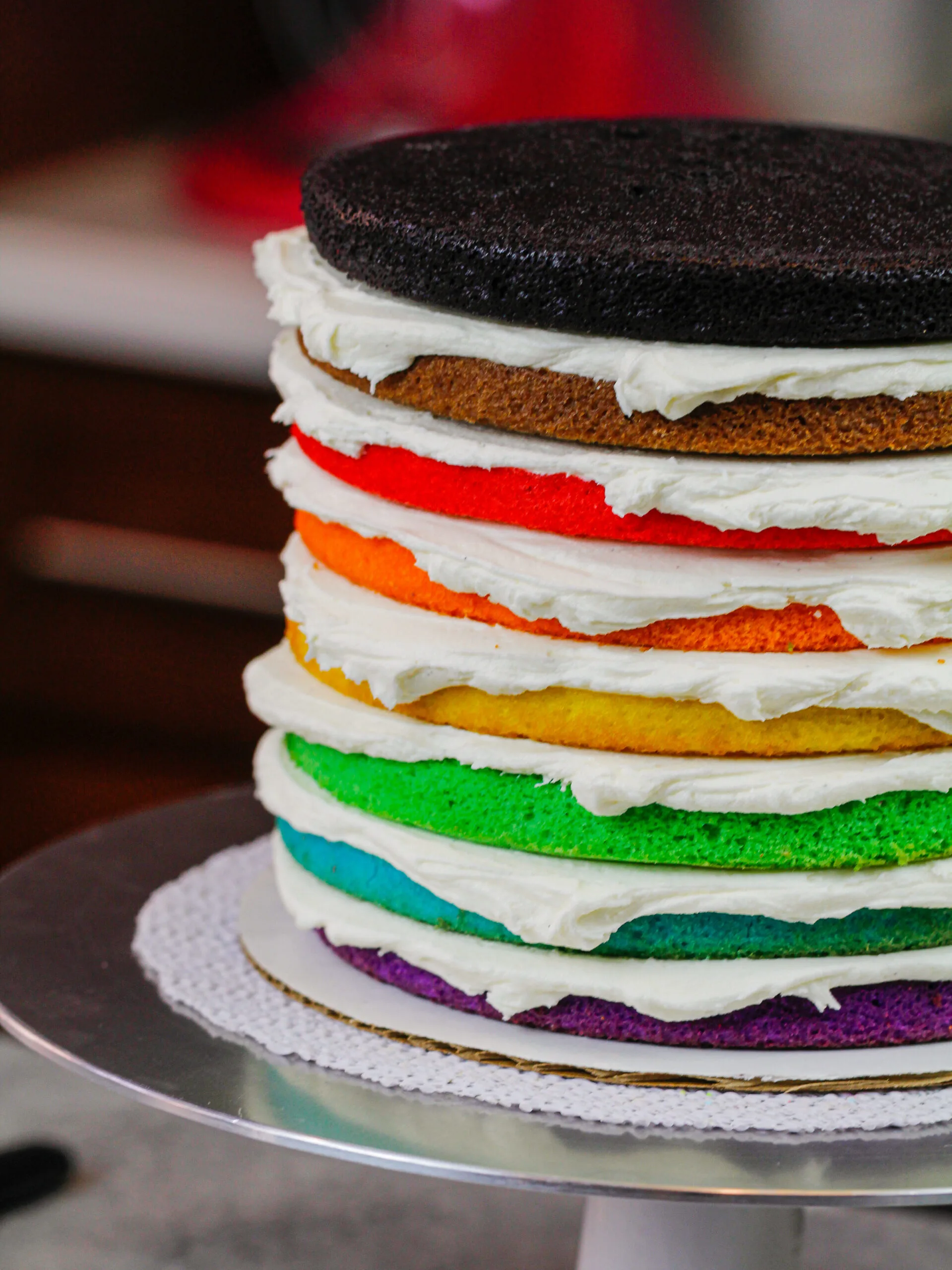 image of 8 color inclusive rainbow cake layers stacked and ready to be crumb coated for pride