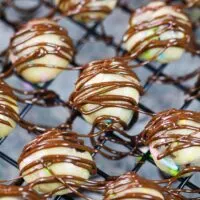 image of cookie dough bites on a wire rack that have been drizzled with melted chocolate