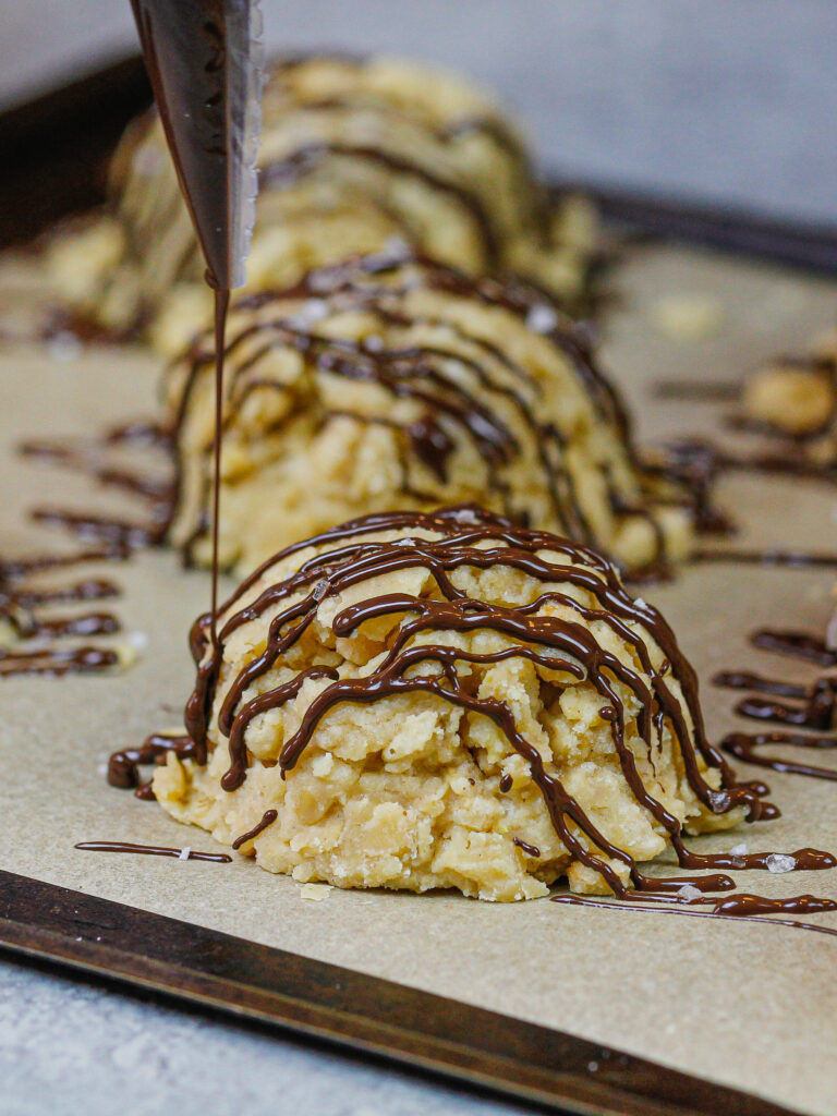 image of gluten free no bake cookies being drizzled with dark chocolate that's shared as part of a no bake recipe round up