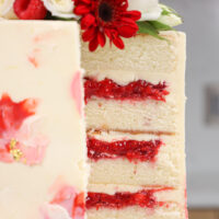 image of a white chocolate raspberry cake that's been cut open to show it's tart. delicious raspberry. cake filling