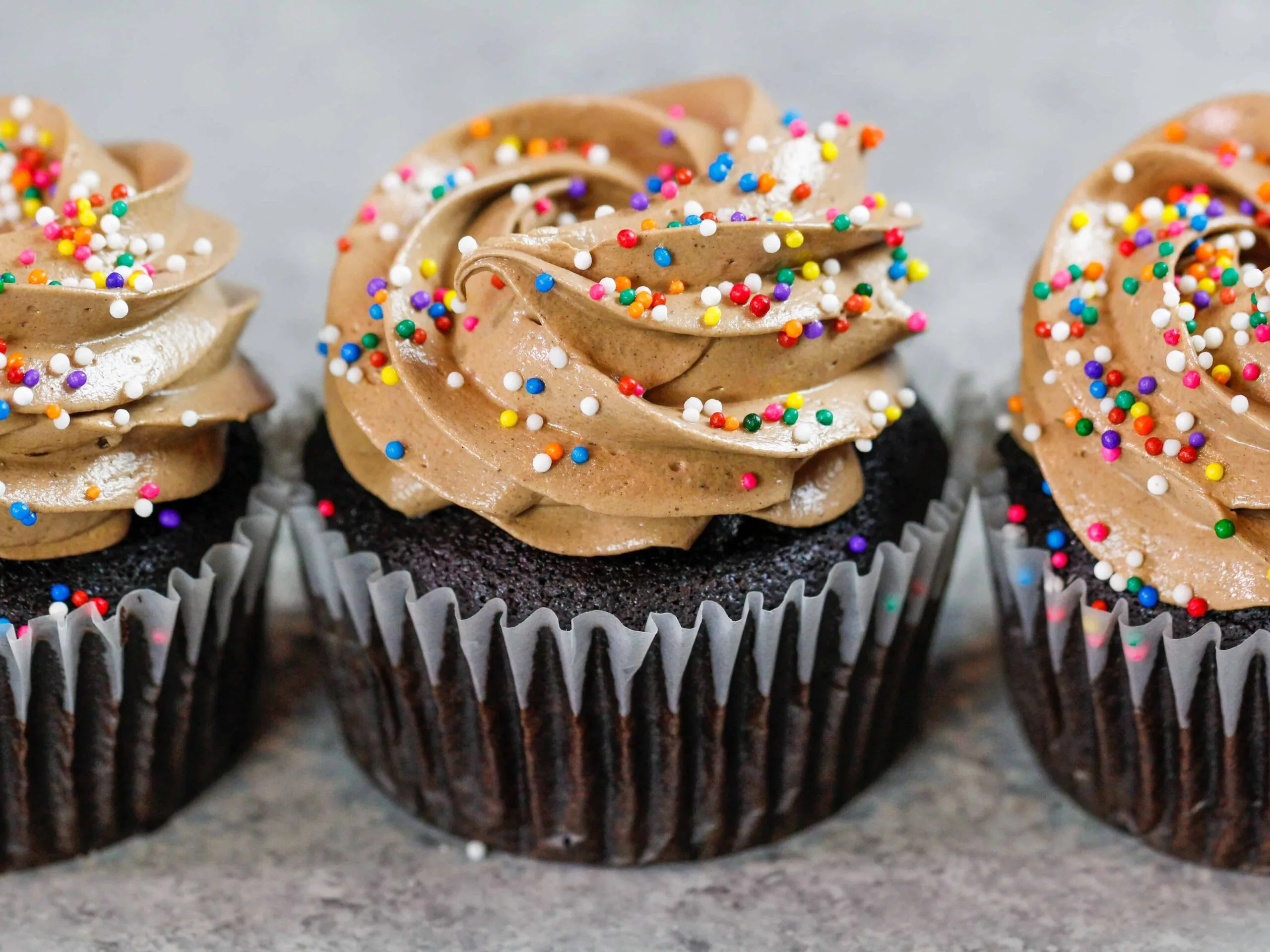image of chocolate italian meringue buttercream frosting on top of cupcakes
