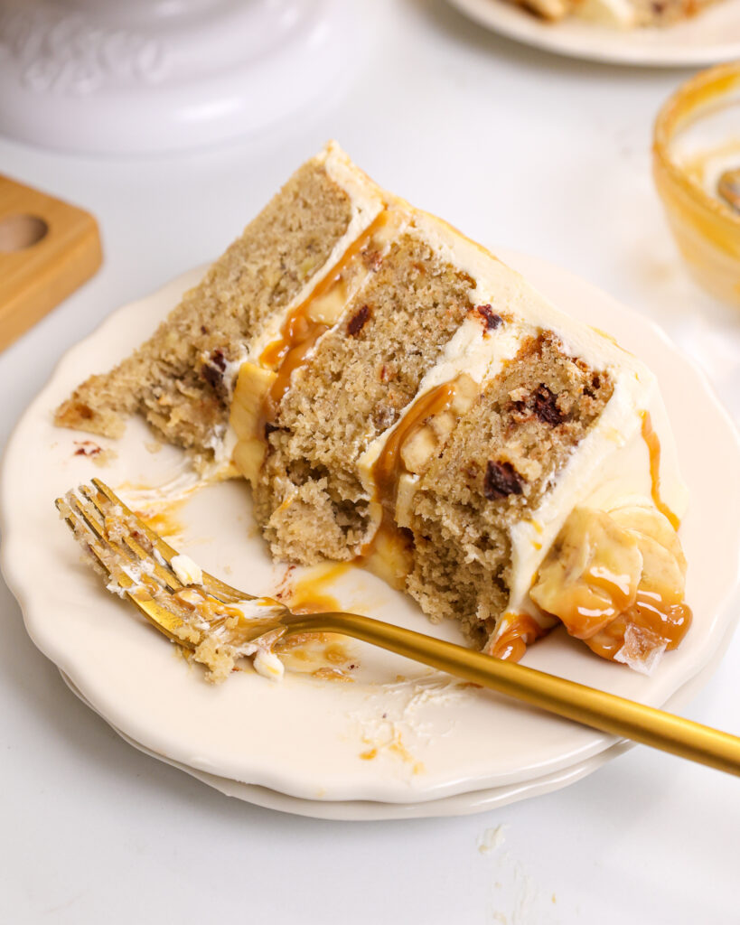 image of a slice of banoffee cake on a plate that's been cut into to show how moist and delicious it is